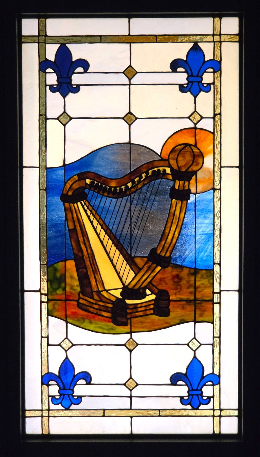 A stained glass window in my chalet by Célyne Laliberté, featuring motifs of a Celtic harp (for Ireland) and fleurs de lys (for Québec)